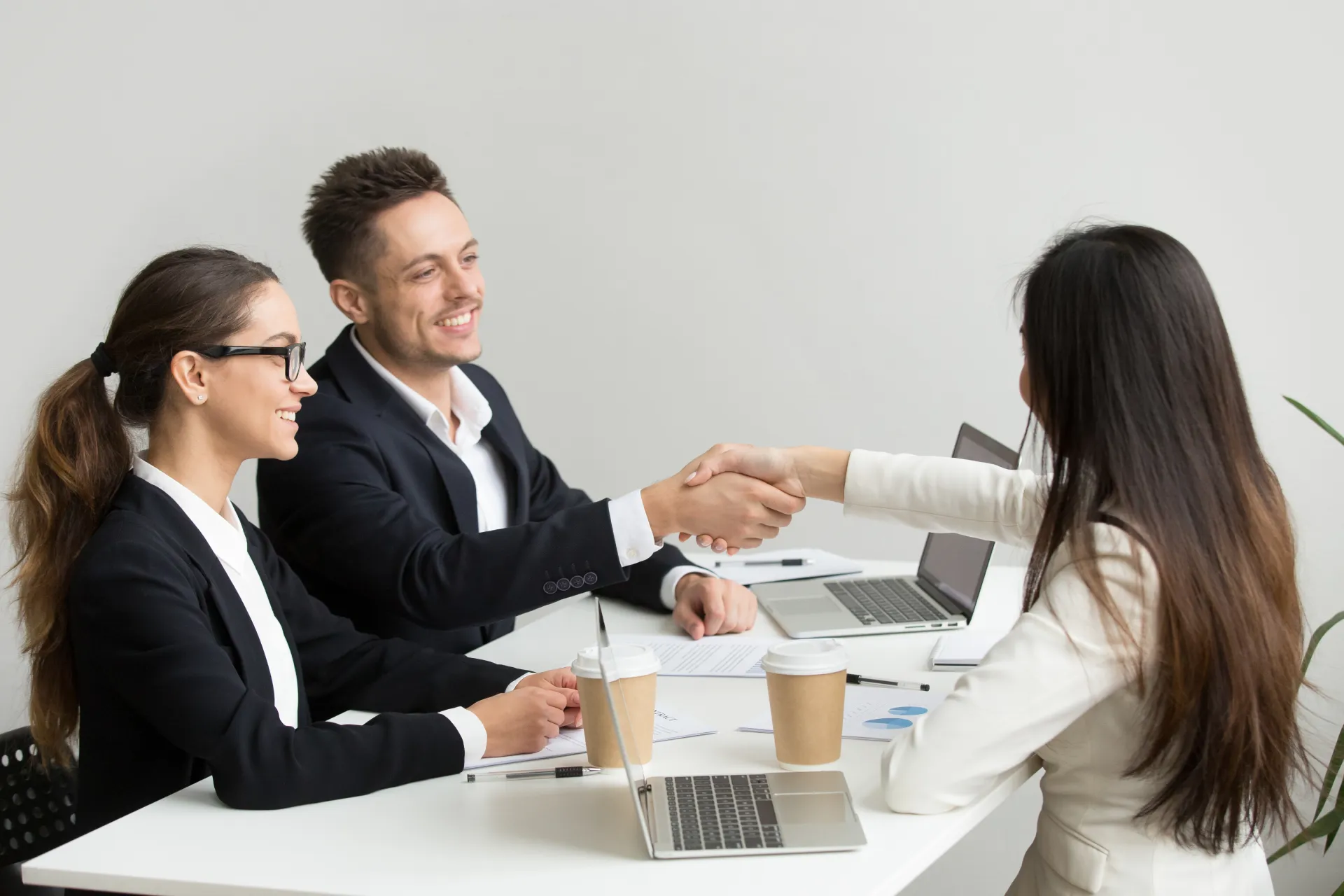 friendly partners handshaking group meeting thanking successful teamwork
